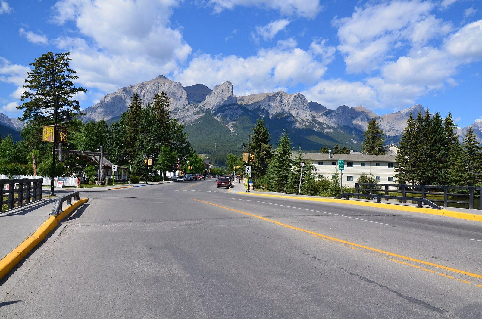 Shops along Canmore Main Street with mountains behind the town