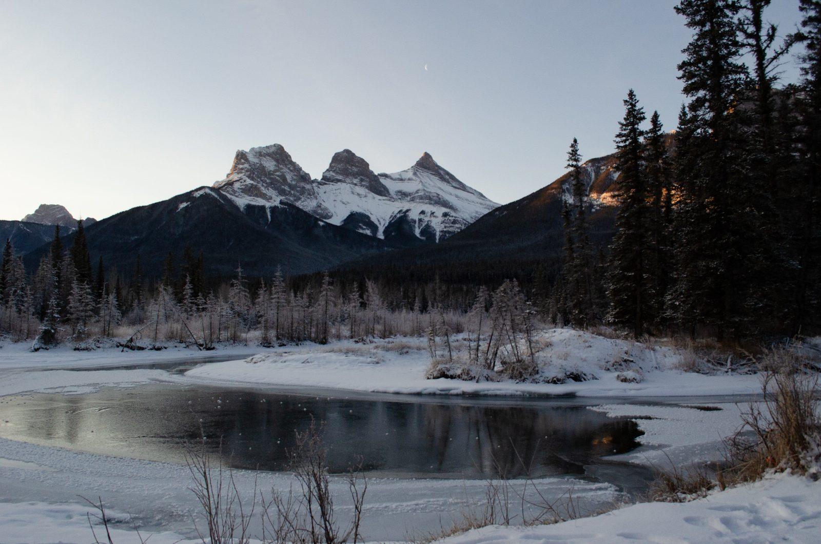 Snow-covered Three Sisters peaks above Policeman’s Creek in Canmore