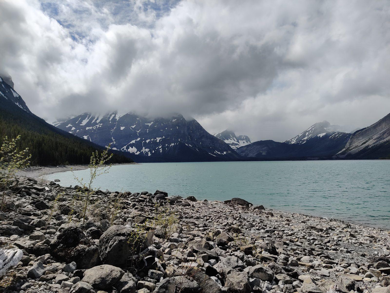 Rocky shoreline and cloud-covered peaks above Upper Kananaskis Lake